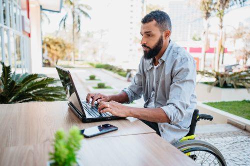 man working with computer in canteen