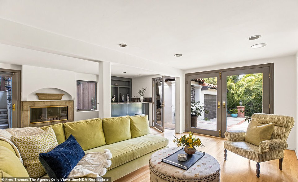 Living Room: The centerpiece of the living room is a whitewashed stone fireplace and an adjacent lounge area overlooking the outdoor grounds