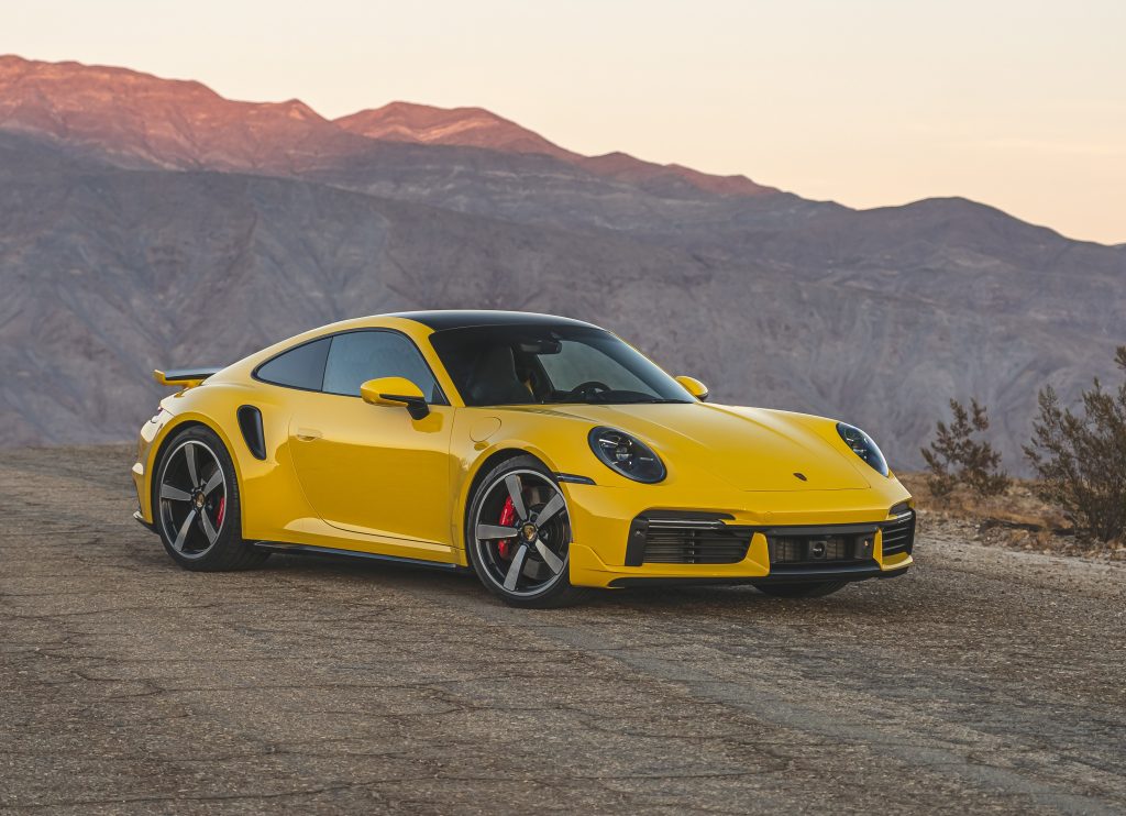 Yellow 2022 Porsche 911 Turbo on desert mountain road